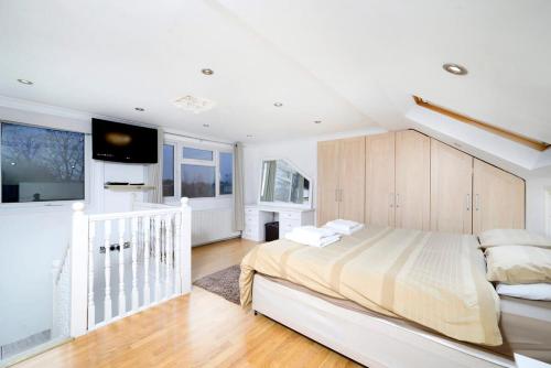 a white bedroom with a large bed and a tv at Chic 2BR Home - Eats and Sights Closeby in London