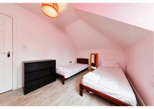 1 Schlafzimmer mit 2 Betten im Dachgeschoss in der Unterkunft Chic Croydon 2BR Flat - Free Parking in Purley