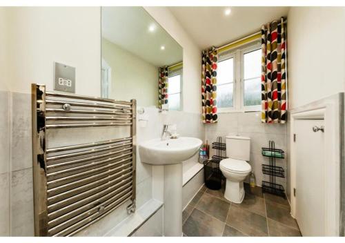 a white bathroom with a sink and a toilet at Chic Croydon 2BR Flat - Free Parking in Purley