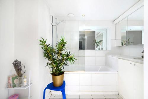 a bathroom with a plant in a blue stool at Central London 2BR Flat with Garden in London