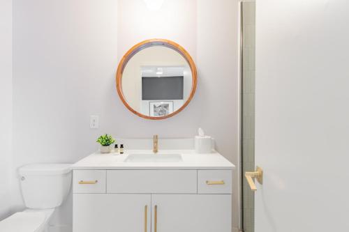 a white bathroom with a sink and a mirror at Outrider 111 by AvantStay 5 Minutes to Broadway in Nashville