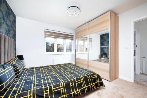 a bedroom with a bed and a large window at Chic and Spacious 3BR Family Home with Garden in Northolt