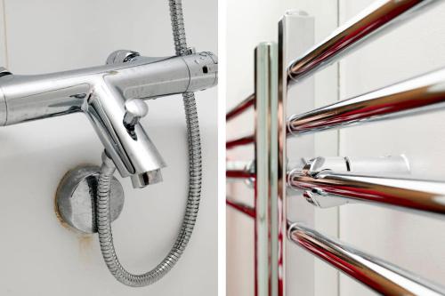 a shower head in a bathroom with a hose at Chic and Spacious 3BR Family Home with Garden in Northolt
