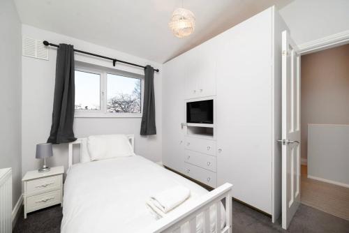 Charming 3BR House with Garden tesisinde bir odada yatak veya yataklar