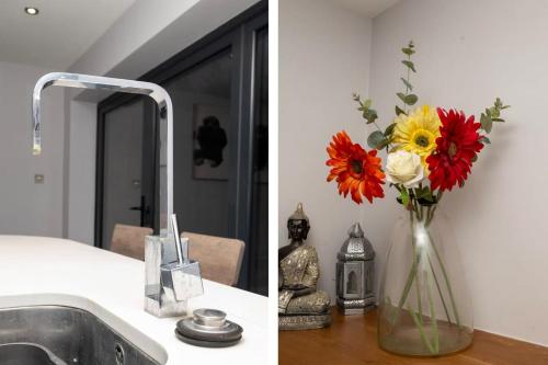 a vase of flowers sitting on a counter next to a sink at Charming 3BR House with Garden in Uxbridge