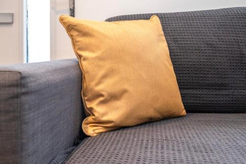 a yellow pillow sitting on top of a couch at Cozy single level flat with parking in Enfield