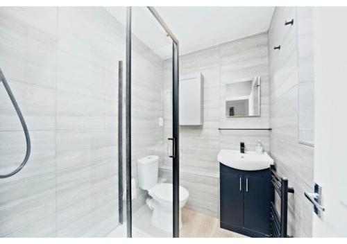 a bathroom with a toilet and a sink and a shower at 5BR Family Home close to Parks and City Links in Purley