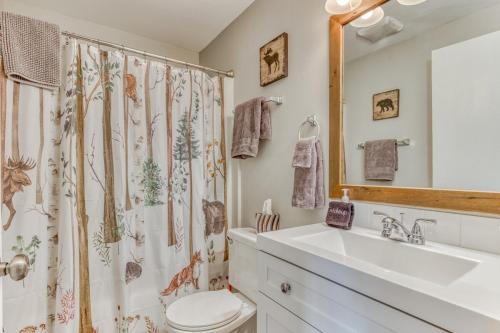 a bathroom with a sink and a toilet and a shower curtain at Thunderhead Lodge Condo 204 - Modern Heated Pool & Games in Government Camp