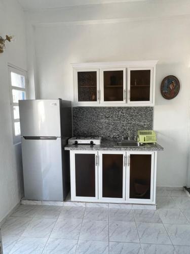 a kitchen with white cabinets and a white refrigerator at YOUR SPACE COLONIAL in Santo Domingo