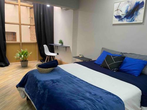 a bedroom with a large bed with blue sheets at [Urban Style Suite] City center + Netflix in Cuenca