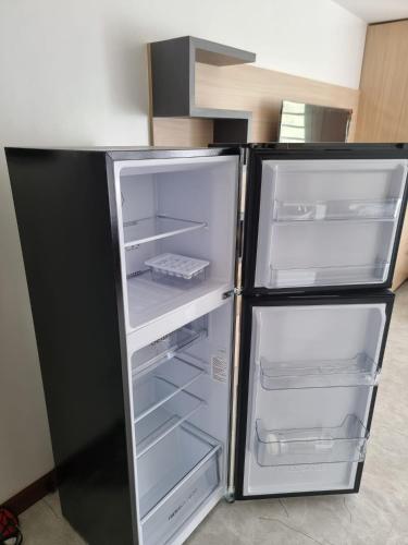 a black refrigerator with its doors open in a kitchen at C Mary's Staycation in Tanza Cavite Condo Type with balcony good for 2 person in Tanza