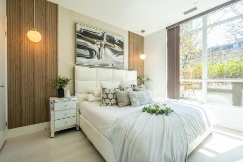 a bedroom with a white bed and a window at Luxury Suite With Private Terrace Downtown Toronto in Toronto