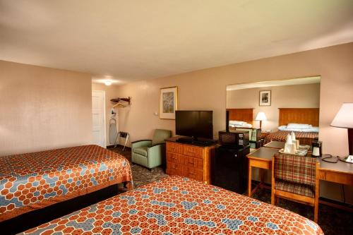 a hotel room with two beds and a desk at Budget Inn Cicero in Cicero