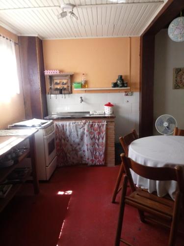 een keuken met een tafel, een wastafel, een tafel en een fornuis bij Chalé Maringá in Bocaina de Minas