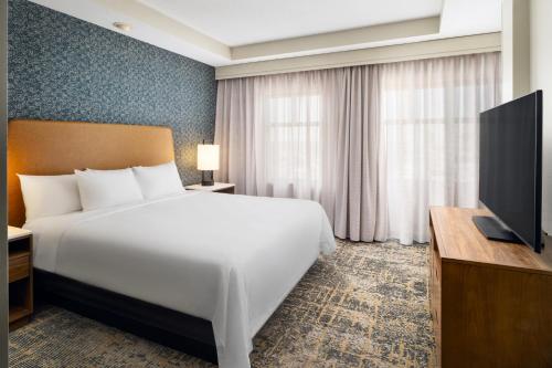 a hotel room with a bed and a television at Embassy Suites Lincoln in Lincoln