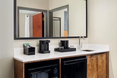 a bathroom with a sink and a microwave at Embassy Suites Lincoln in Lincoln