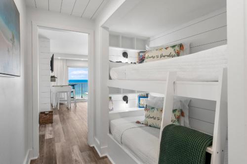 a bedroom with two bunk beds and a desk at The Summit 808 - Luxury Beach Resort Condo - Beachfront - Incredible Views - BEACH CHAIRS AND SUNSHADE Provided In Condo in Panama City Beach