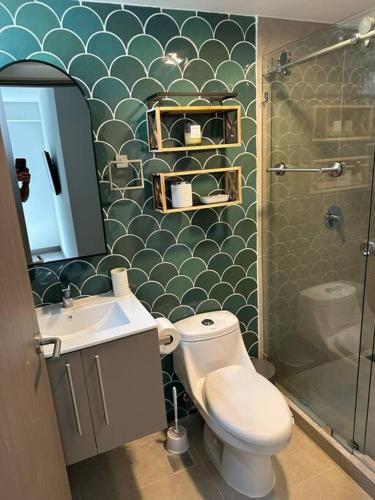 a bathroom with a toilet and a sink and a shower at Punta Verde Beach Condo in Tarcoles