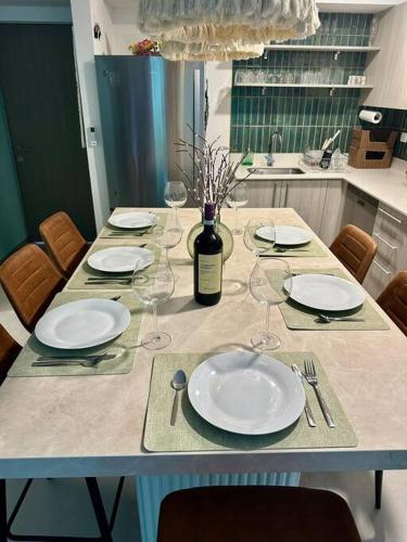 a table with plates and glasses and a bottle of wine at Punta Verde Beach Condo in Tarcoles