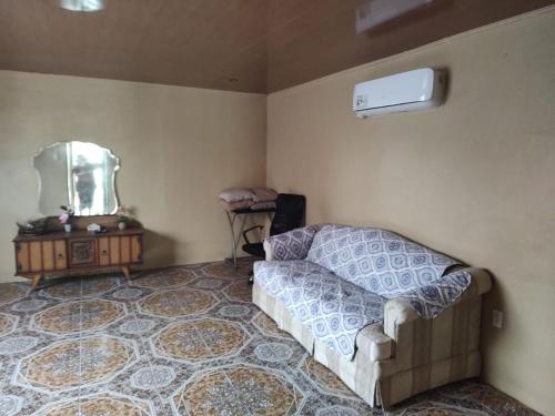 een woonkamer met een bank en een spiegel bij Casa 28 Millas in Madre de Dios