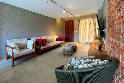 a living room with two couches and a brick wall at Casa Beverly Hills Pysá 02 Milagres Nobile Stays in São Miguel dos Milagres
