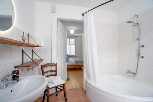 een witte badkamer met een bad en een wastafel bij AMW18 Ferienwohnung Alte Liebe in Häven