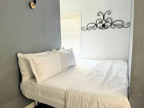 a bed with white sheets and pillows in a bedroom at Mangosteen in New Orleans