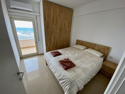 Schlafzimmer mit einem Bett und Meerblick in der Unterkunft Costante 614 in Durrës