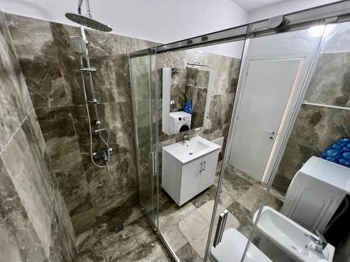 een badkamer met een douche en een wastafel bij Beach 600 in Golem