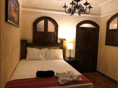 a bedroom with a bed with a hat on it at Casa Familiar San Sebastian in Antigua Guatemala