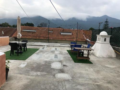 a patio with tables and chairs on a roof at Casa Familiar San Sebastian in Antigua Guatemala