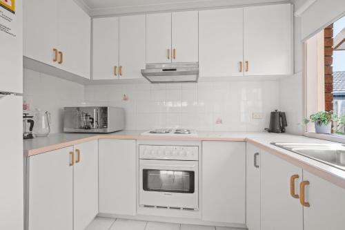 a white kitchen with white cabinets and a sink at StayAU 3BRM Family Home Netflix Pet-Friendly in Narre Warren South