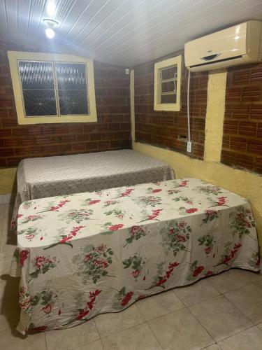 una camera con due letti con una coperta sopra di Chácara com uma área de lazer top a Caruaru