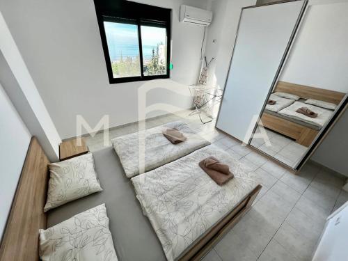 ein Bad mit 2 Betten und einem Spiegel in der Unterkunft Nouveau 623 in Durrës