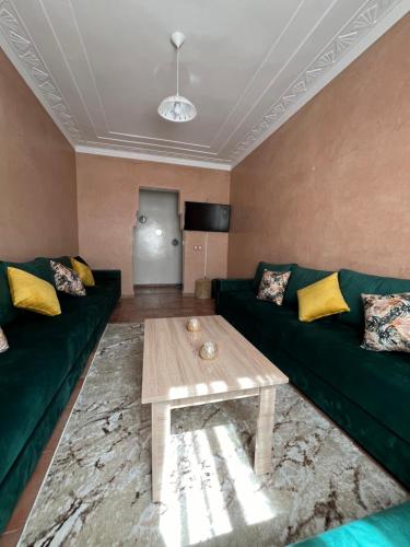 sala de estar con sofá verde y mesa de centro en Superbe appartement au porte de gueliz, en Marrakech