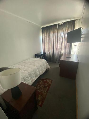 a hotel room with a bed and a window at NEW HOTEL CRUZ DEL SUR in Concepción