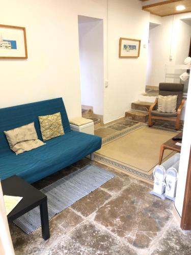 a living room with a blue couch and stairs at Apartamento 2 Penedo in Sintra