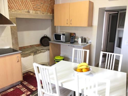 a kitchen with a table with a bowl of fruit on it at Apartamento 2 Penedo in Sintra