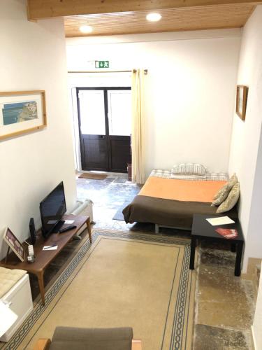 a bedroom with a bed and a desk and a door at Apartamento 2 Penedo in Sintra