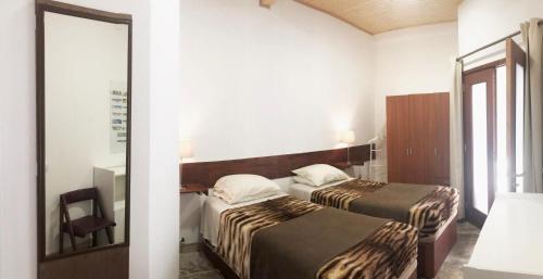 シントラにあるApartamento 2 Penedoのベッド2台と鏡が備わるホテルルームです。