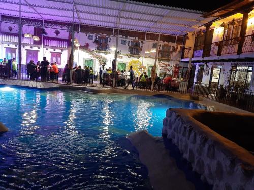 una piscina de agua en un edificio con gente de pie alrededor en HOTEL LA VILLA DE LUISA EN VILLa DE LEYVA, en Sáchica