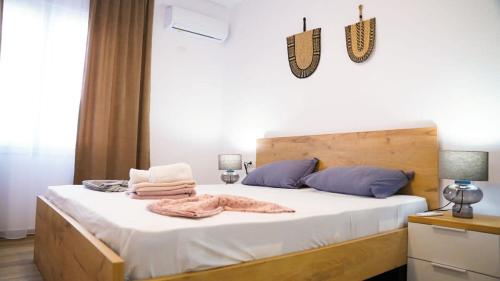 een slaapkamer met een groot bed met witte lakens en blauwe kussens bij Vacation 943 in Durrës