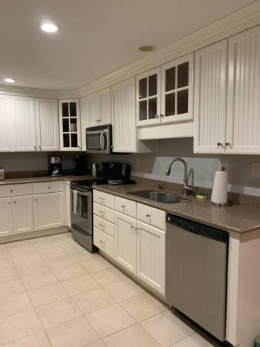 a kitchen with white cabinets and a sink at Entire home! Waterfront and Trail-backing! in Beaufort