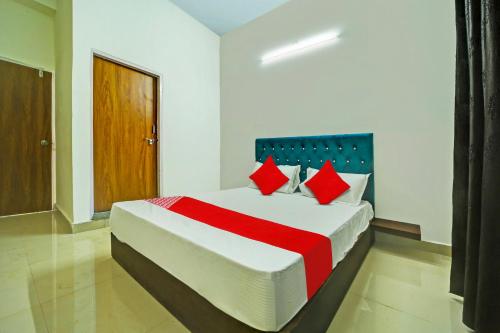 a bedroom with a large bed with red pillows at OYO H.S HOTEL in Bhopal