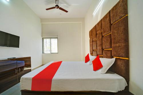 a bedroom with a large bed with red and white pillows at OYO H.S HOTEL in Bhopal