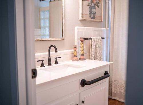 W łazience znajduje się biała umywalka i lustro. w obiekcie Family friendly getaway w mieście North Richland Hills