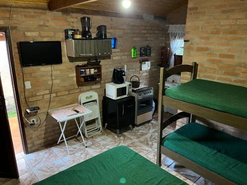 a room with a kitchen with a stove and a microwave at Chalé Ibiti in Conceição da Ibitipoca