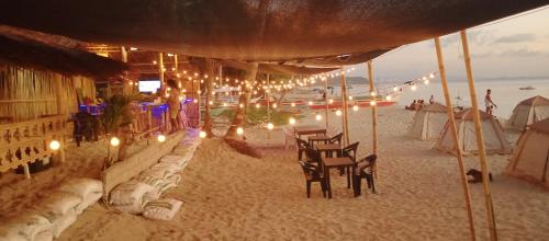 a beach with chairs and lights on the sand at Amwani Sunset Colours Camping Site in San Vicente