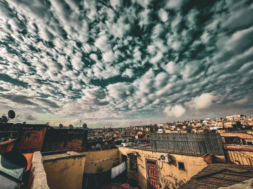 Blick auf eine Stadt unter einem wolkigen Himmel in der Unterkunft Riad Rasia in Fès