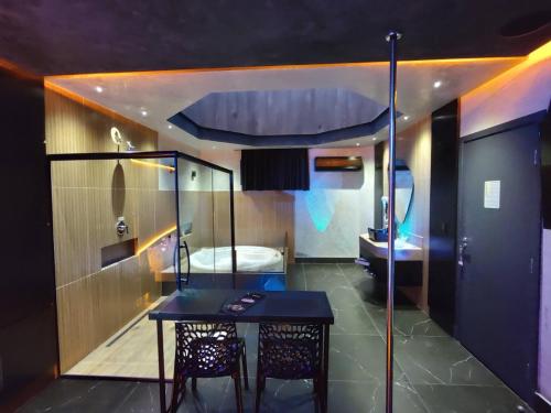 a room with a table and a bathroom with a sink at Prestige Motel 5 in Sorocaba